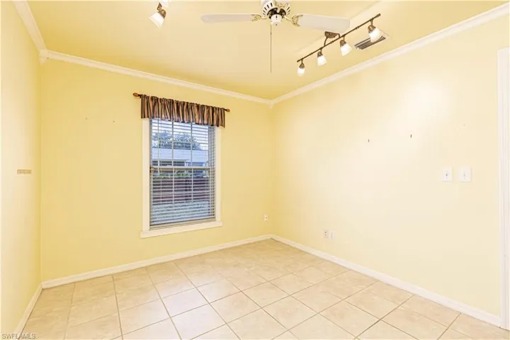 Spare room with crown molding, ceiling fan, light tile patterned floors, track lighting, and baseboards