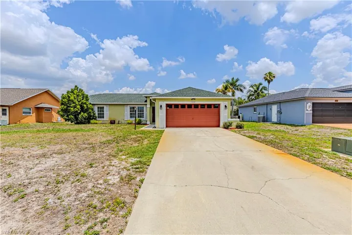 Ranch-style house featuring an attached garage, concrete driveway, stucco siding, cooling unit, and a front yard