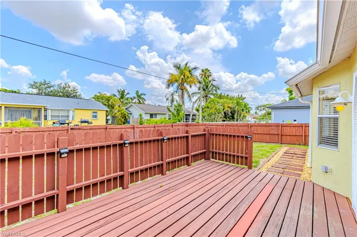 Wooden deck with a fenced backyard and a residential view