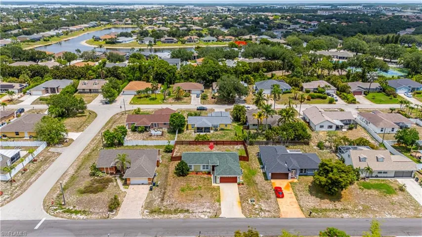 Aerial perspective of suburban area featuring a nearby body of water