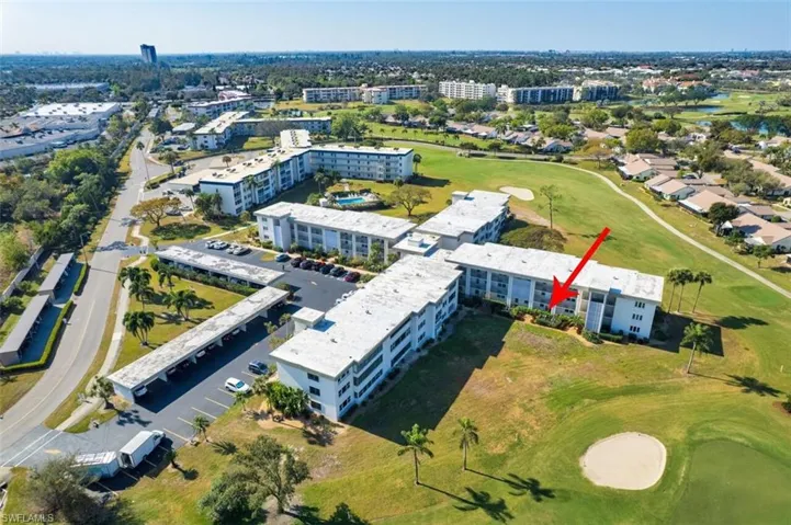 View of property location featuring a golf course and apartment complex / building