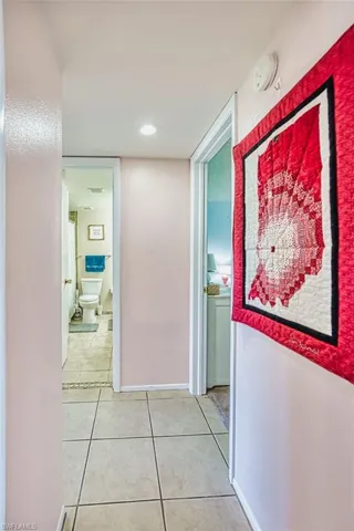 Corridor with light tile patterned floors and recessed lighting