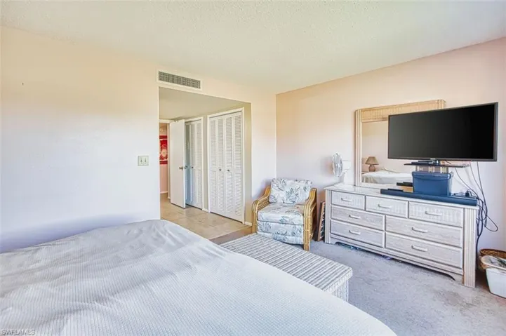 Carpeted bedroom with a textured ceiling and a closet