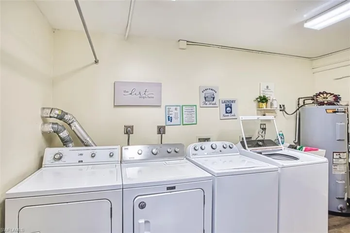Laundry area featuring electric water heater and separate washer and dryer
