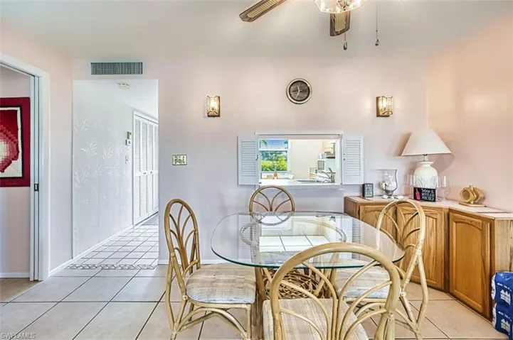 Dining area with light tile patterned floors and a ceiling fan