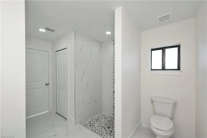 Doorway with baseboards and marble look tiles