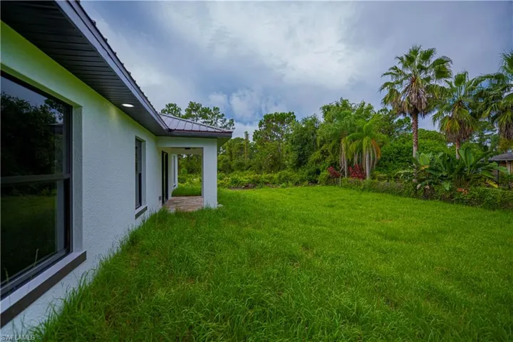 View of grassy yard with a patio