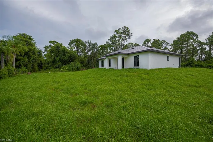 View of grassy yard with view of scattered trees