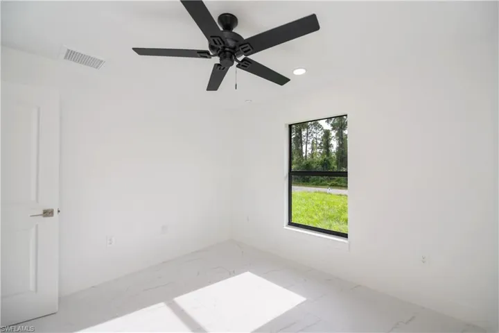 Spare room featuring light marble finish floors, recessed lighting, and a ceiling fan