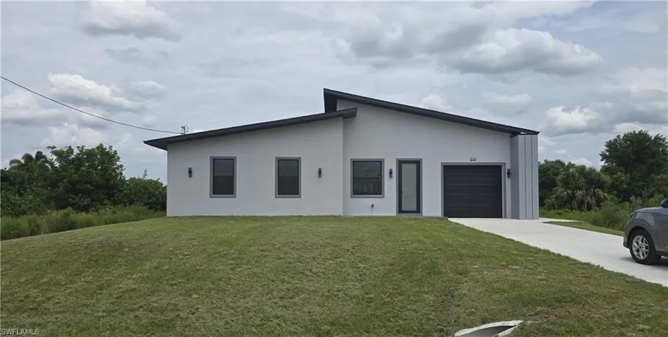 Contemporary single-story residence with a gray stucco exterior and dark trim windows