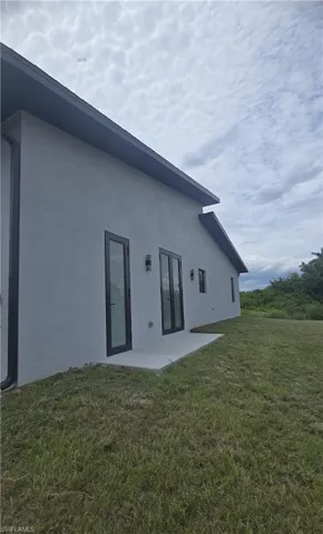 Modern exterior with light gray stucco finish and black trim