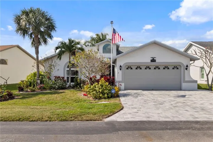 View of front of house with a garage and a front lawn