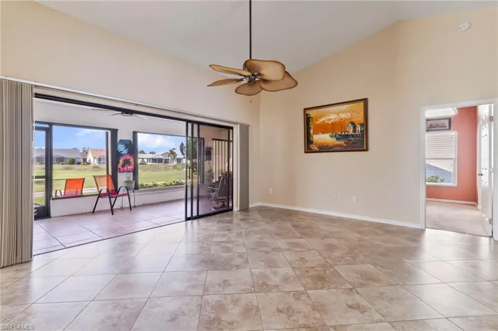 Living room featuring light tile patterned flooring, ceiling fan, a healthy amount of sunlight, and high vaulted ceiling