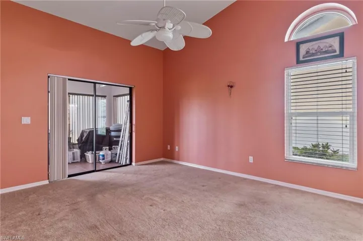 Primary bedroom with ceiling fan, plenty of natural light, and high vaulted ceiling