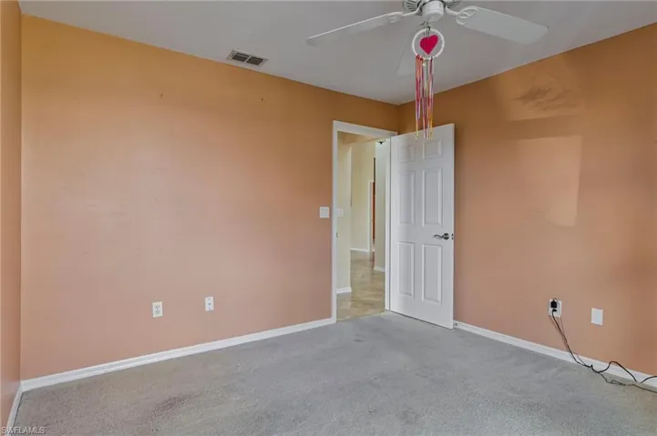 Carpeted guest bedroom featuring ceiling fan