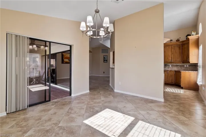 Dining area with light tile patterned floors and a chandelier