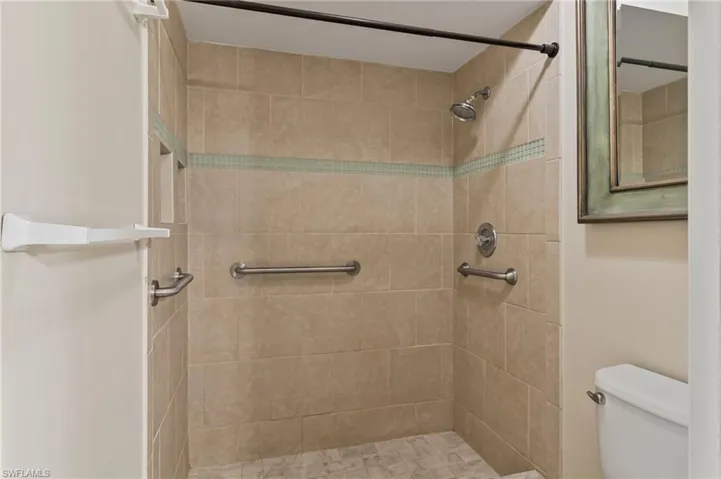 En suite athroom featuring a tile shower and toilet