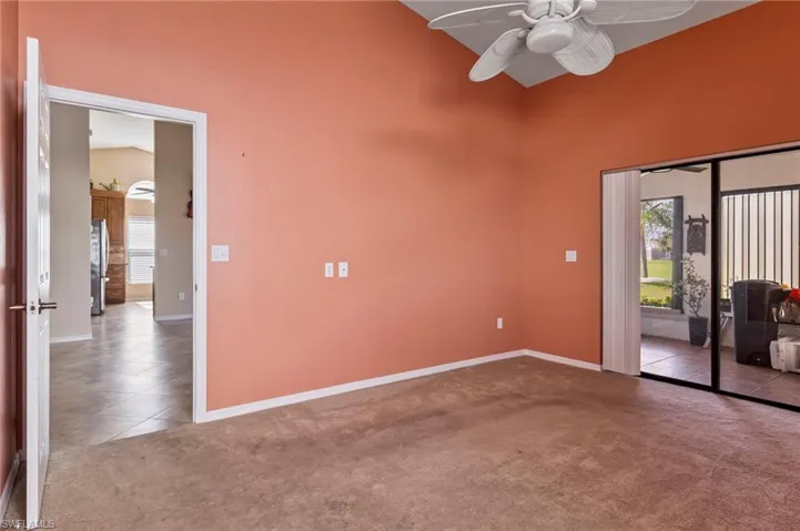 Primary bedroom with high vaulted ceiling and ceiling fan