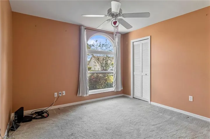 Guest bedroom featuring light carpet and ceiling fan