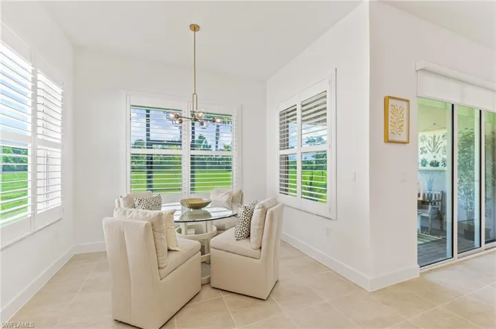 Dining room features plantation shutters anddesigner lighting
