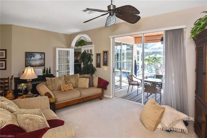Carpeted living area with a ceiling fan