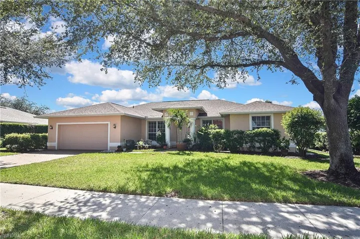 Ranch-style home with a front yard, stucco siding, driveway, an attached garage, and a shingled roof
