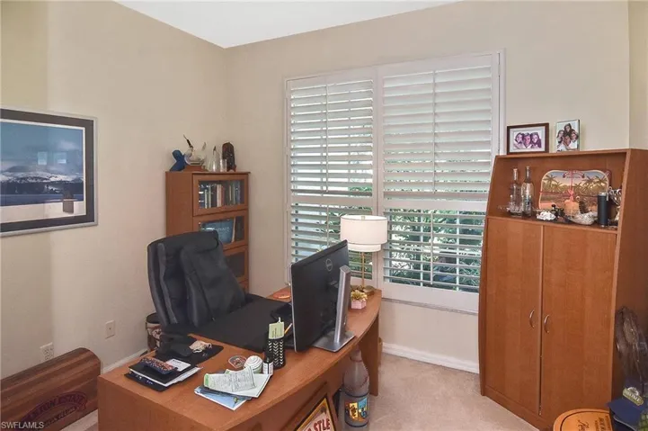 Home office with baseboards and light colored carpet