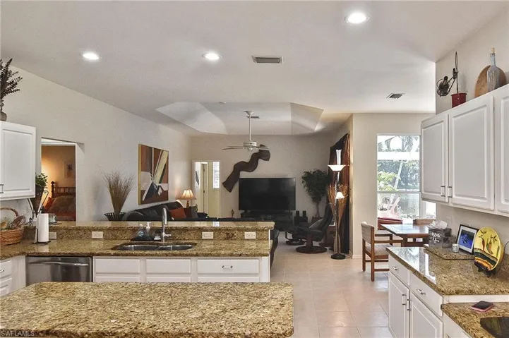 Kitchen with white cabinets, a peninsula, open floor plan, and recessed lighting