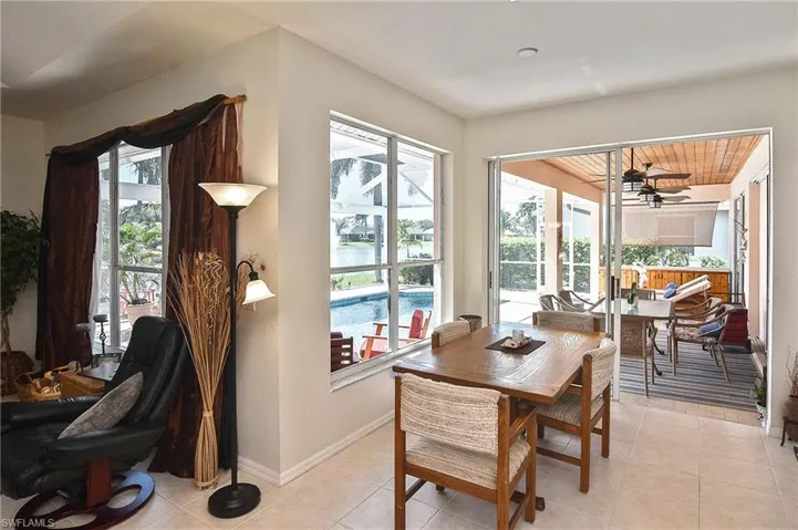 Dining area with light tile patterned floors, a water view, and a ceiling fan