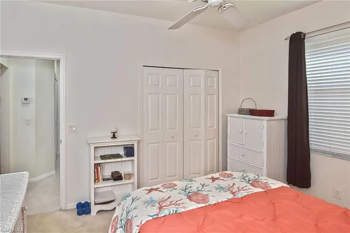 Bedroom featuring a closet, a ceiling fan, and light carpet