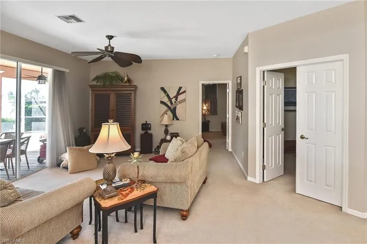 Living room with light colored carpet and a ceiling fan