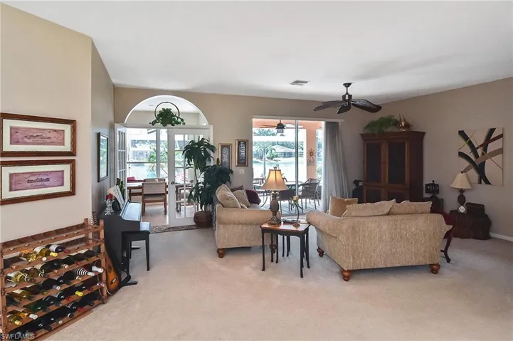 Living area featuring light colored carpet and a ceiling fan
