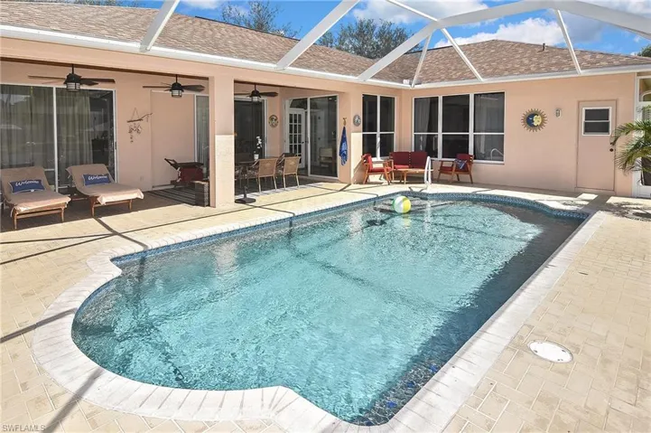 Outdoor pool featuring a patio, a sunroom, ceiling fan, a lanai, and outdoor lounge area