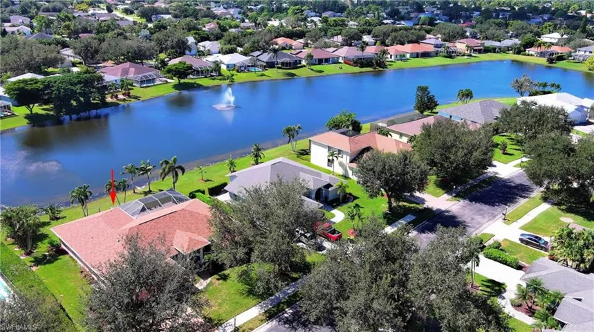 Aerial view of residential area featuring a nearby body of water