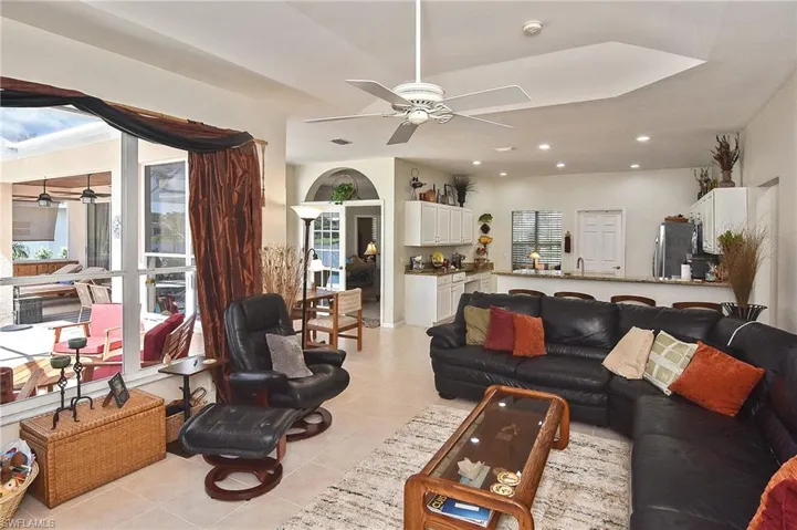 Living area with ceiling fan, light tile patterned floors, recessed lighting, and arched walkways