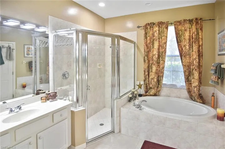 Bathroom with a stall shower, a bath, vanity, light tile patterned floors, and recessed lighting