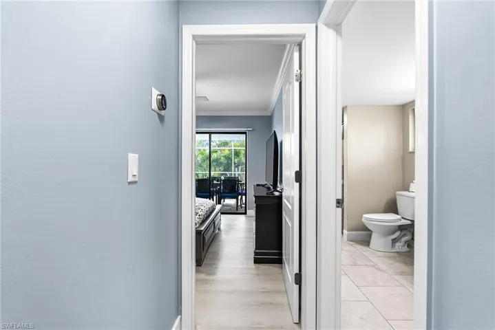 Hall with ornamental molding and light wood finished floors