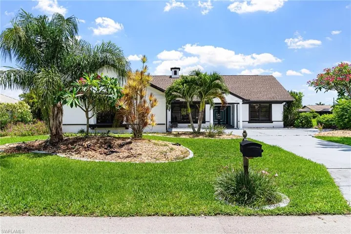 View of front of home featuring a front lawn, a shingled roof, and stucco siding