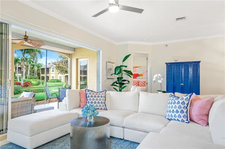 Bright and airy living room with triple sliders to screened lanai.