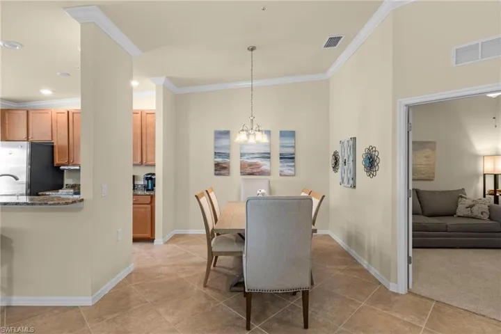 Dining room with visible vents, baseboards, a notable chandelier, and crown molding