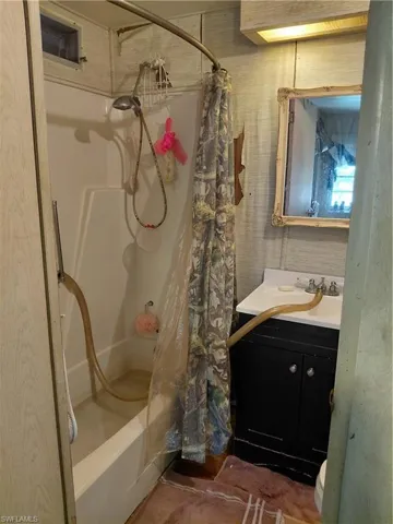 Full bathroom featuring shower / bathtub combination with curtain and vanity