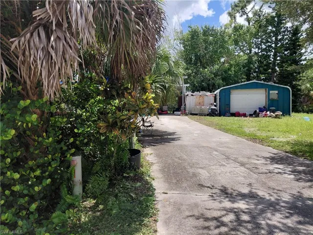 View of property exterior featuring an outbuilding and driveway