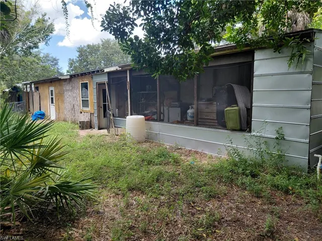 Rear view of house featuring a sunroom and a yard