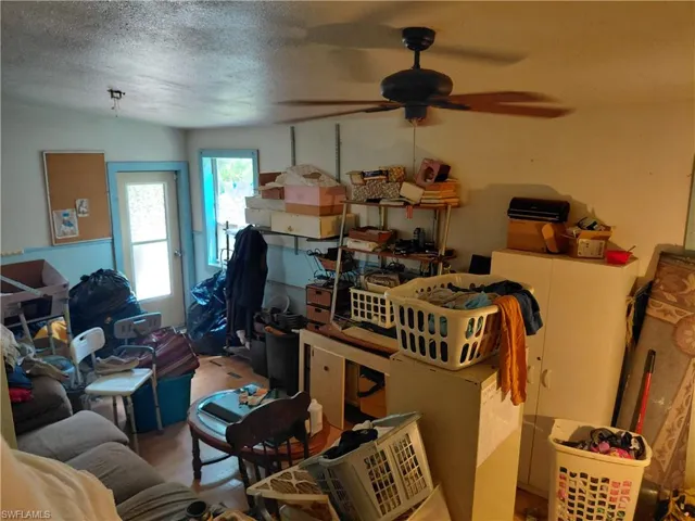 Misc room with a textured ceiling and a ceiling fan
