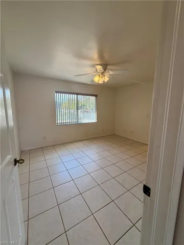 Spare room with ceiling fan and light tile patterned flooring