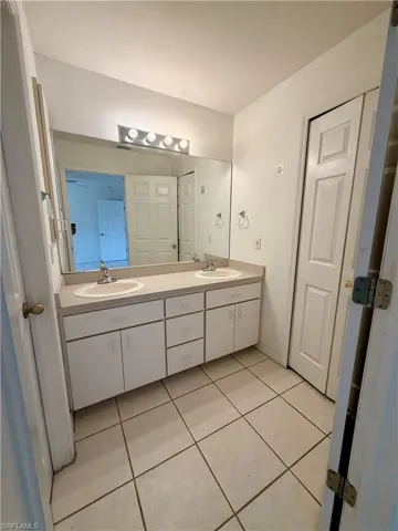 Bathroom featuring double vanity and light tile patterned floors