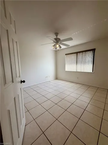 Spare room featuring a ceiling fan and light tile patterned floors