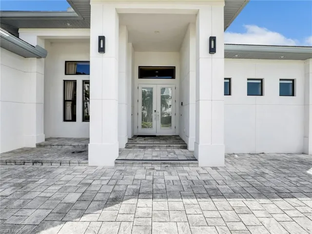 Entrance to property featuring french doors, a patio area, and stucco siding