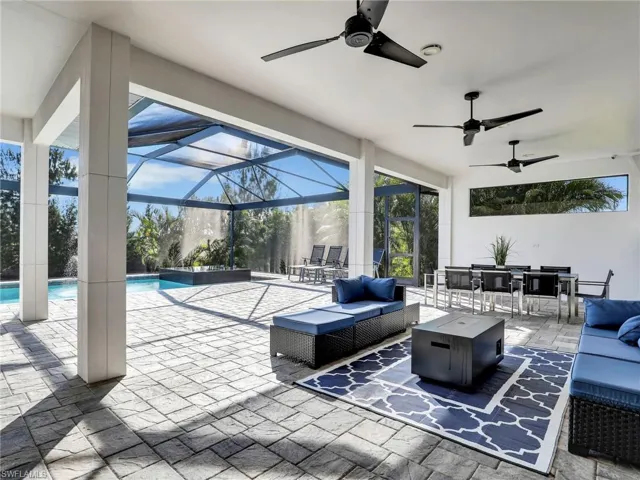 View of patio with an outdoor living space with a fire pit, a sunroom, outdoor dining area, and a ceiling fan