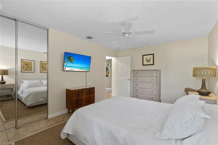 Bedroom featuring a ceiling fan, light tile patterned floors, and a closet